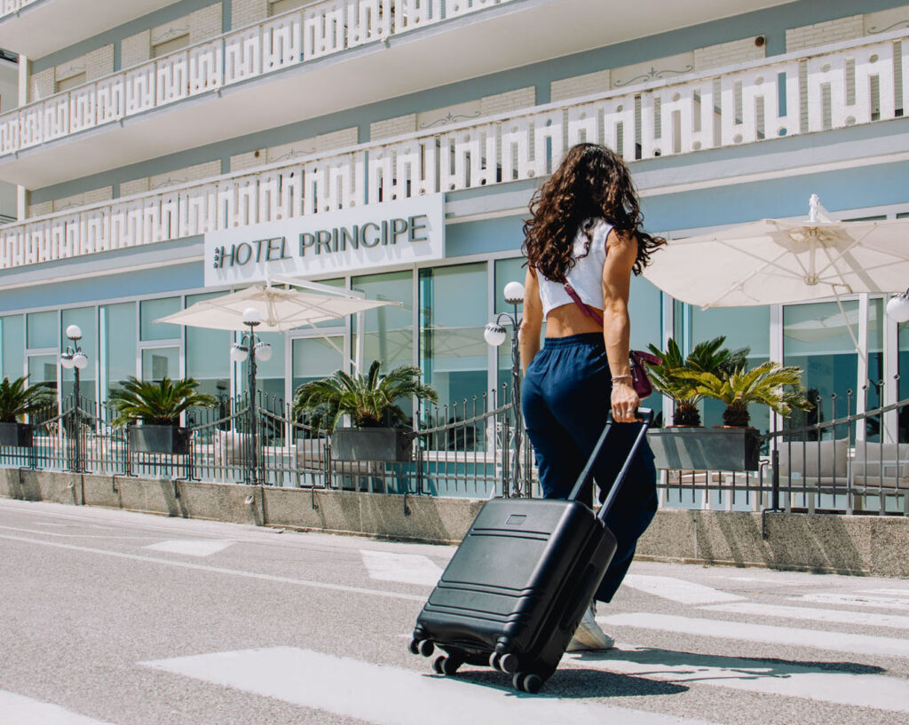ragazza con valigia che sta raggiungendo l'hotel principe, vediamo la facciata dell'hotel