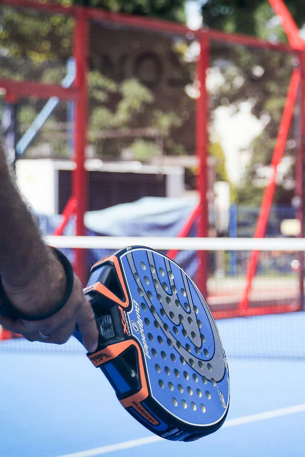 uomo con racchetta da padel che sta giocando aspettando di colpire la pallina