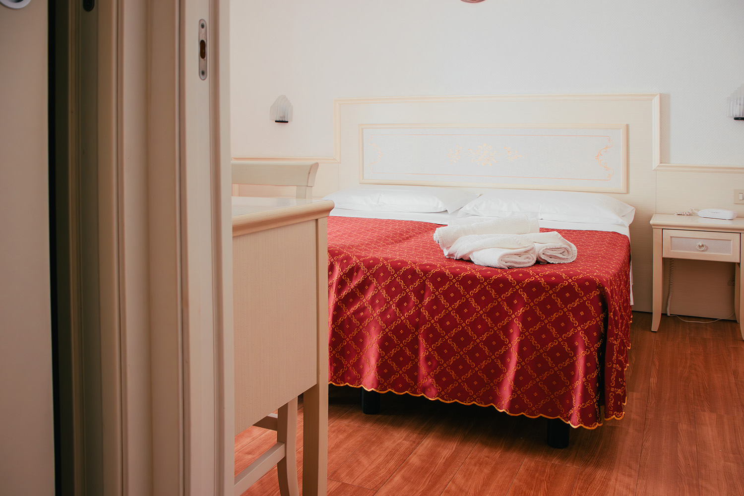 letto matrimoniale della camera family comunicante con lenzuola rosse